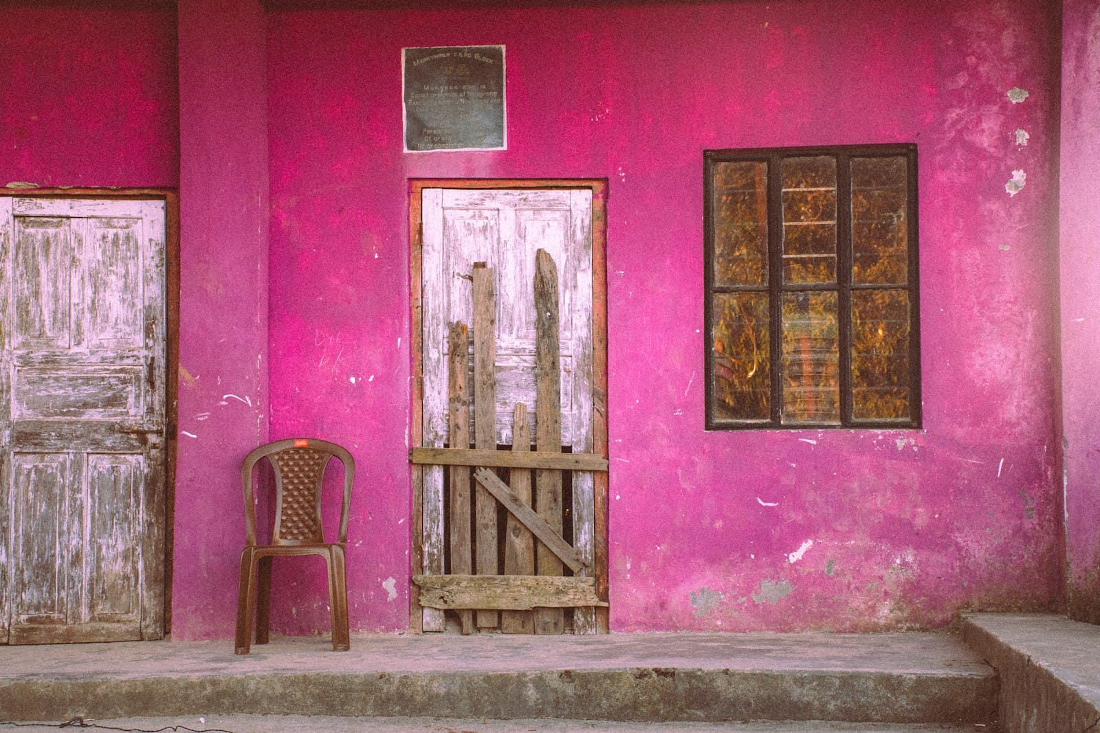 The doorway of a pink village home