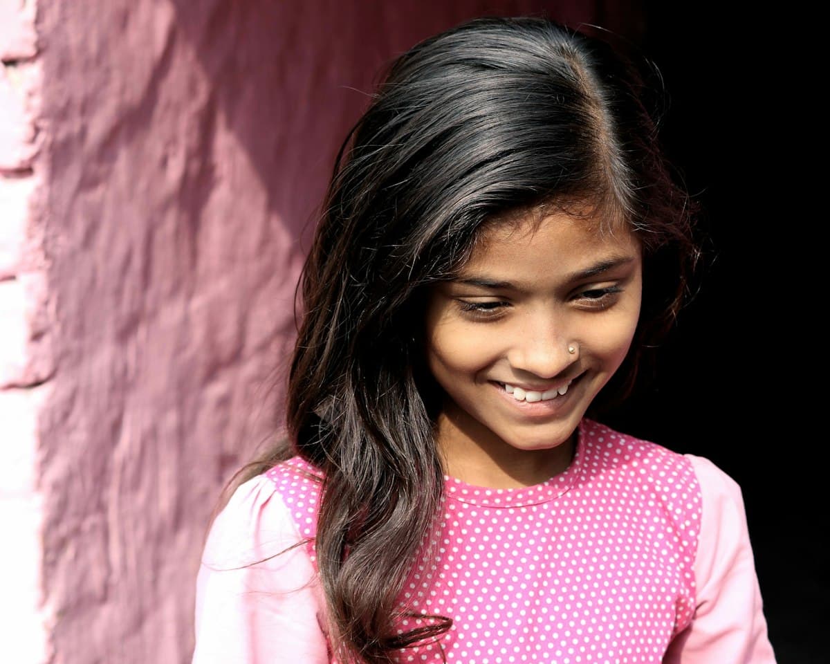 A smiling girl in a pink top