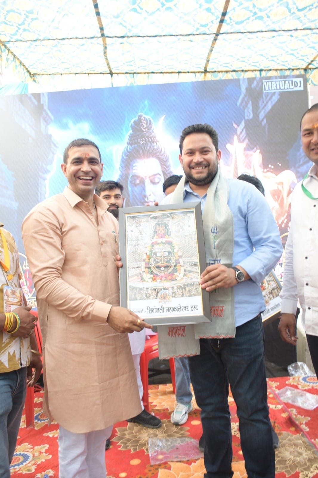 एक अतिथि को महाकालेश्वर का फ्रेम किया चित्र भेंट करते हुए हँसते रविंदर सांगवान